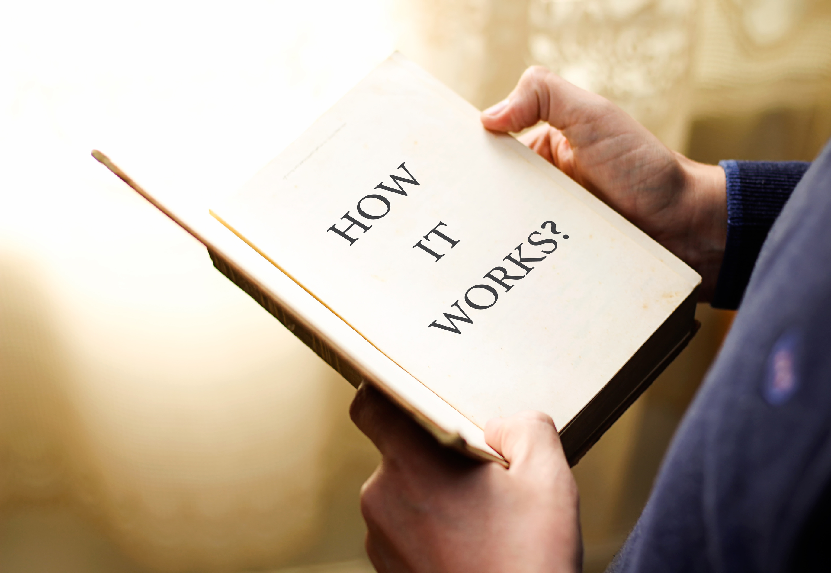 Businessman holding a book with text How it works